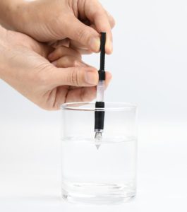 水を入れたコップにペン先を浸して水の吸入と排出を繰り返す 